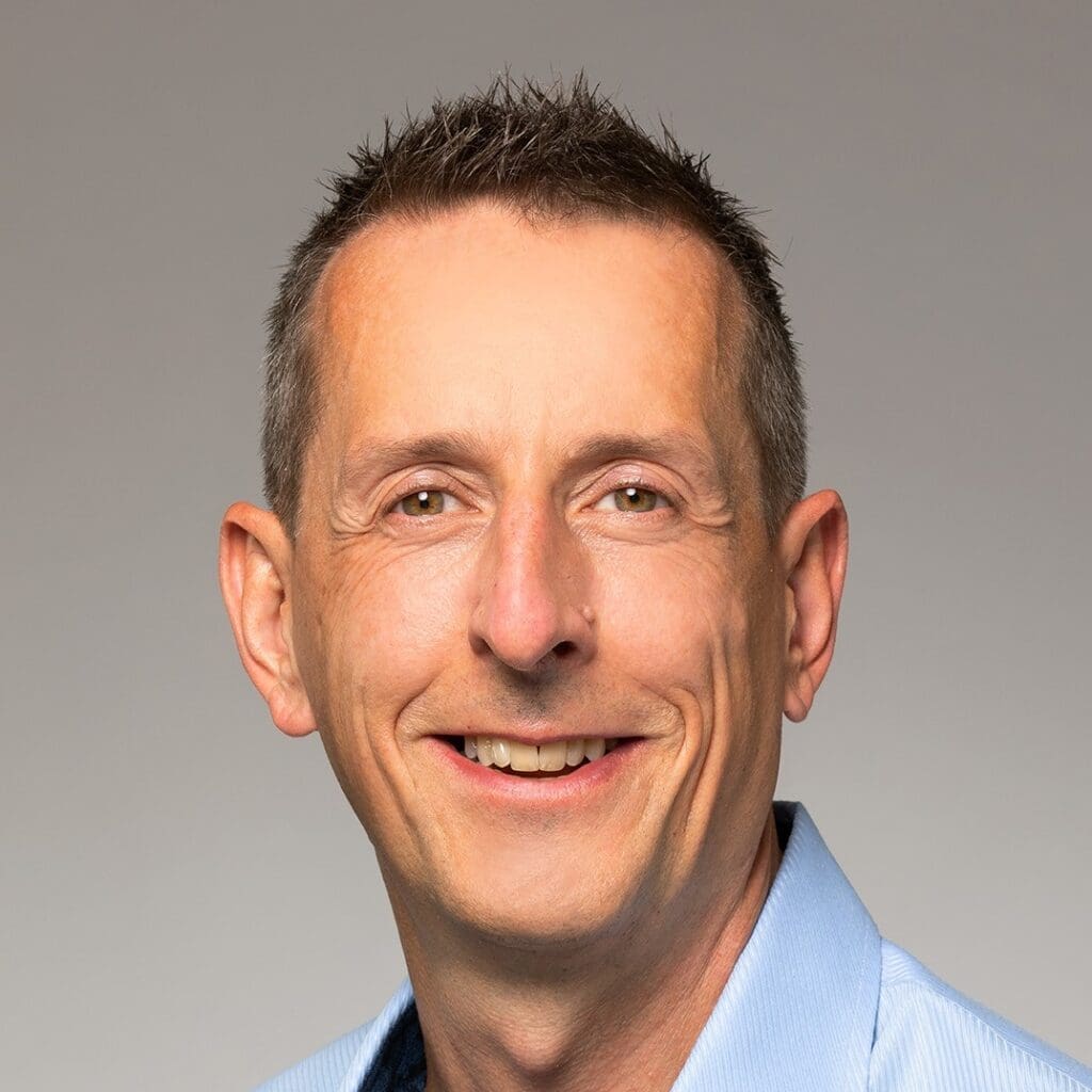 Yves Käser, Porträtfoto in hellblaumen Hemd.